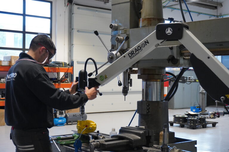 A plant manager evaluating the specifications of a Roscamat electric tapping machine integrated with a CNC machining center.