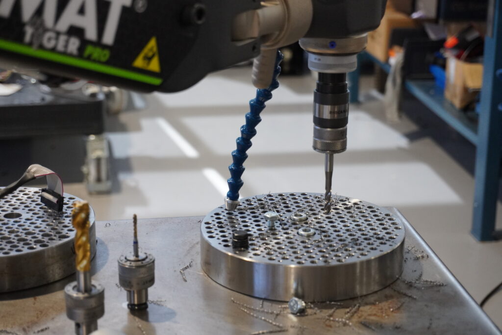 Auxiliary workstation that optimizes a CNC machining center using a Roscamat articulated arm.