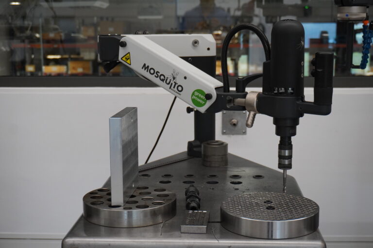 Robotic arm and digital control system at a workstation equipped with high-speed Roscamat industrial threading machines.